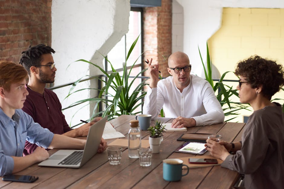 A group of colleagues in a modern office having a strategic discussion around a wooden table